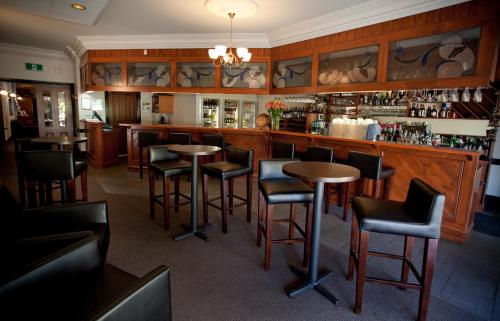 a bar with tables and chairs in a restaurant at Mercure Port of Echuca in Echuca