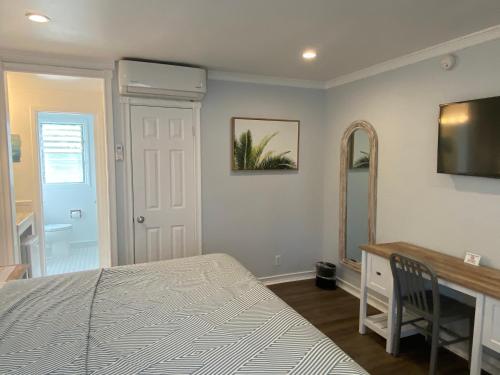 a bedroom with a bed and a desk and a mirror at Ocean Lodge Santa Monica Beach Hotel in Los Angeles