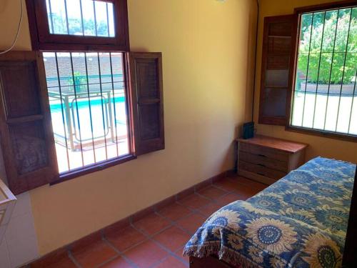a bedroom with a bed and windows with a pool at Casa Departamento Funes Bella Vista Wifi Cochera Pileta in Funes