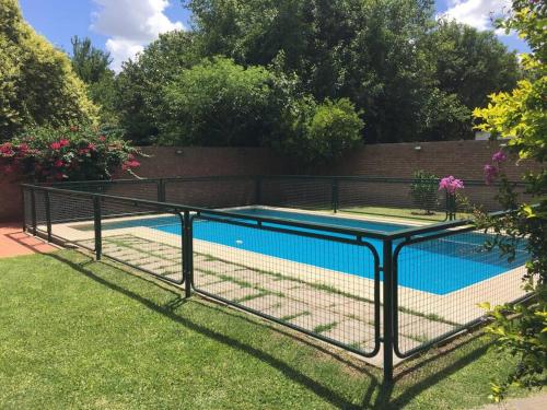 una valla alrededor de una piscina en un patio en Casa Departamento Funes Bella Vista Wifi Cochera Pileta en Funes