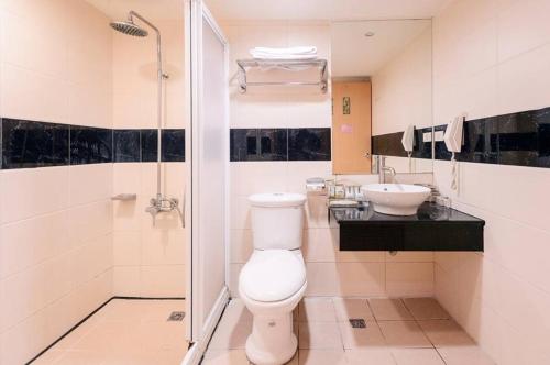 a bathroom with a toilet and a sink at Waugh Den Business Hotel in Taichung