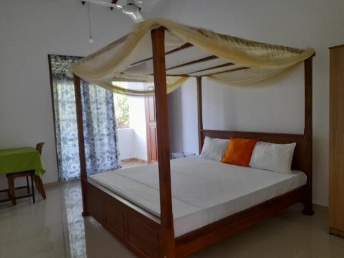 um quarto com uma cama de dossel em Muthuarana Villa Matara em Matara