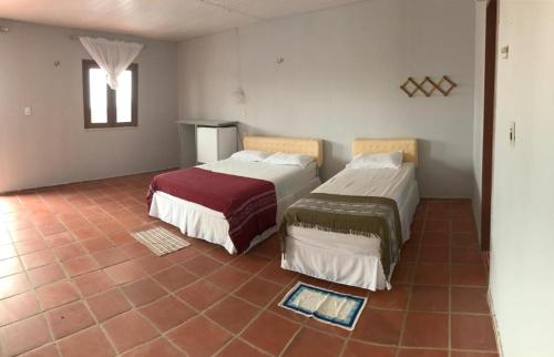 1 dormitorio con 2 camas y suelo de baldosa en Recreio das Fontes, en Beberibe