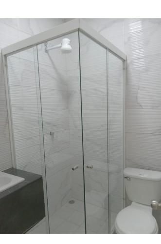 a bathroom with a glass shower with a toilet at Hotel Sabana Inn in San José