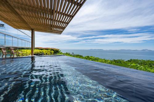 a swimming pool in a house with a view of the ocean at KAMENOI HOTEL Ako in Ako