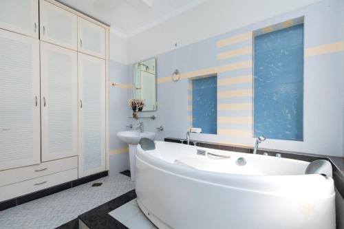 uma casa de banho branca com uma banheira e um lavatório em Rio TD5 homestay em Vung Tau