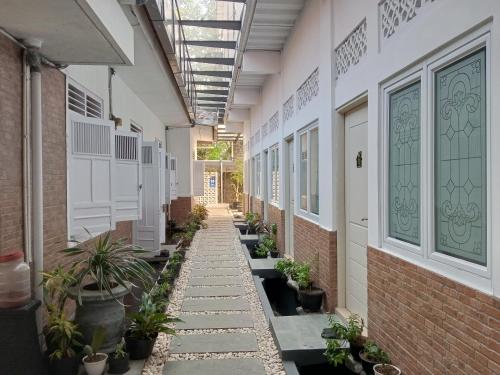 an empty hallway of a building with plants at Bu Sepuh GuestHouse in Sangkanurip