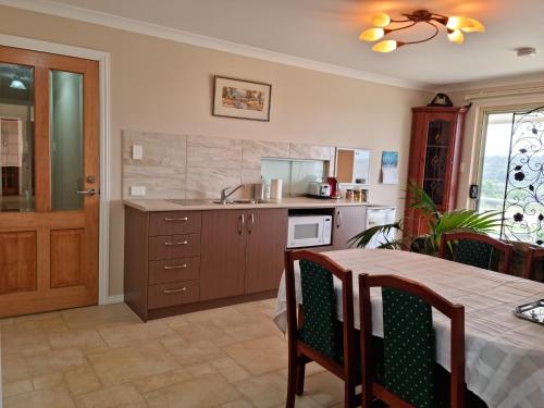 a kitchen with a table and a sink and a counter at Albany Hidden Valley Bed and Breakfast 