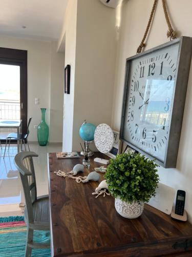 ein Wohnzimmer mit einer großen Uhr an der Wand in der Unterkunft Magical Seaside Town Boutique Apts 2 in Kyparissia