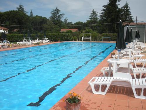 una grande piscina con sedie bianche e un pallone da calcio di Nostra Signora Del Lago a Ronciglione
