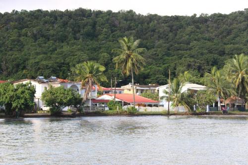 un grupo de casas en la orilla de un cuerpo de agua en Le Colibri et le Frangipanier en La Trinité