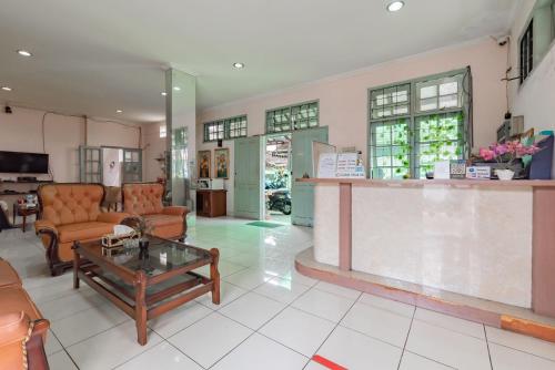 een woonkamer met een bank en een tafel bij Urbanview Hotel Pondok Kurnia Cijagra Bandung in Bandung