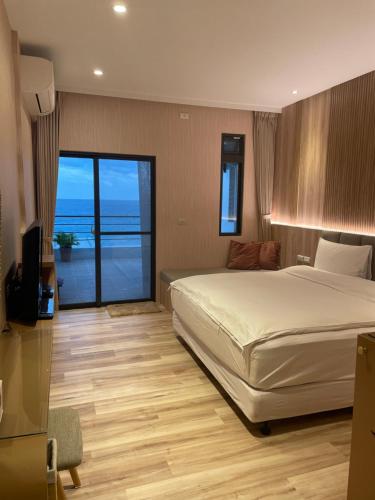 a bedroom with a bed and a view of the ocean at Beach Shoes Villa in Yanliau
