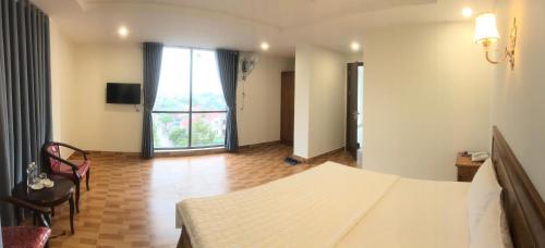 a bedroom with a bed and a large window at Trường Thịnh Hotel in Vinh