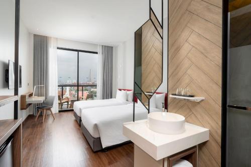 a hotel room with a white bed and a sink at Centara Life Hotel Bangkok Phra Nakhon in Bangkok