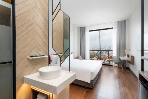 a hotel room with a bed and a sink at Centara Life Hotel Bangkok Phra Nakhon in Bangkok