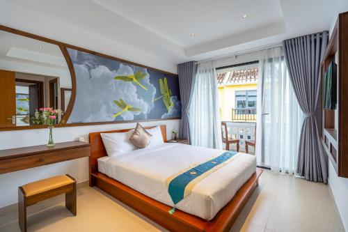 a hotel room with a bed and a window at The Present River Villa Hoi An in Hoi An