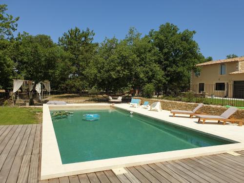 - une piscine dans un jardin avec une terrasse en bois dans l'établissement Mas de la Chêneraie Blanche, Maison de vacances avec piscine en Luberon, à Roussillon