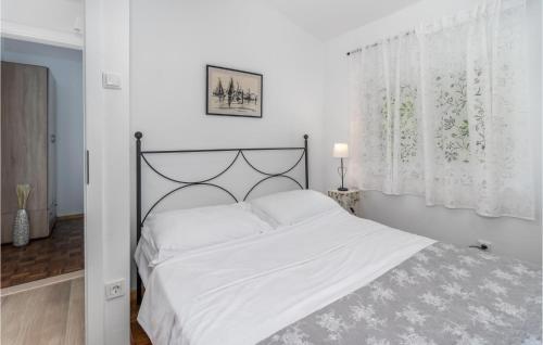 a bedroom with a large white bed with white sheets at Beautiful Home In Crikvenica With Kitchen in Crikvenica