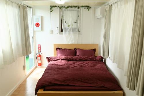 een slaapkamer met een groot bed met paarse kussens bij Mkグリーンホテル in Kawaguchi