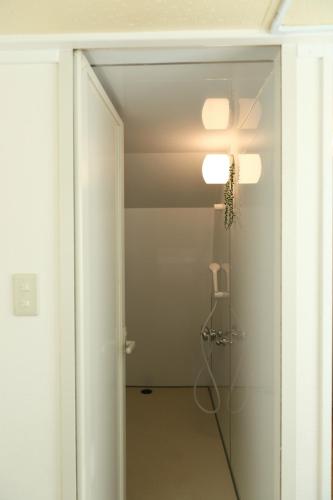 a bathroom with a shower and a glass door at Mkグリーンホテル in Kawaguchi