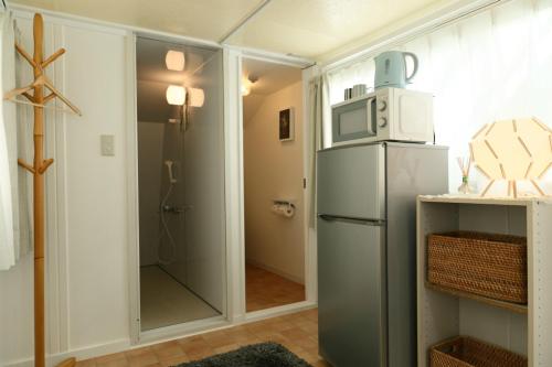 a kitchen with a refrigerator with a microwave on top of it at Mkグリーンホテル in Kawaguchi