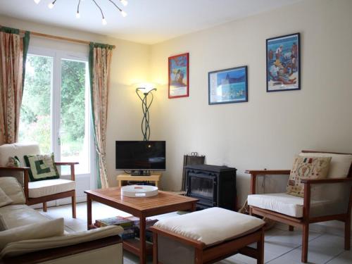 Il comprend un salon doté de meubles et d'une télévision. dans l'établissement Maison récente 4 pièces avec piscine, accès privé à la mer et parking à Saint-Pierre-d'Oléron - FR-1-246A-165, à Saint-Pierre-dʼOléron