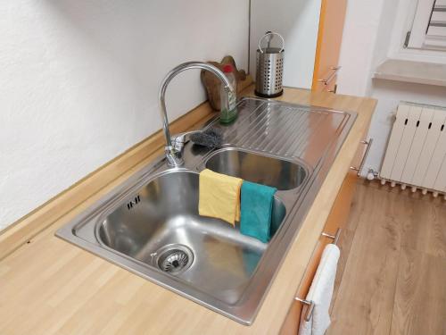 a stainless steel sink in a kitchen with a wooden floor at Appartamento vista Parco Adamello Brenta in Ossana