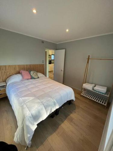 een slaapkamer met een groot bed met een roze kussen bij Cabañas Valdivia central in Valdivia