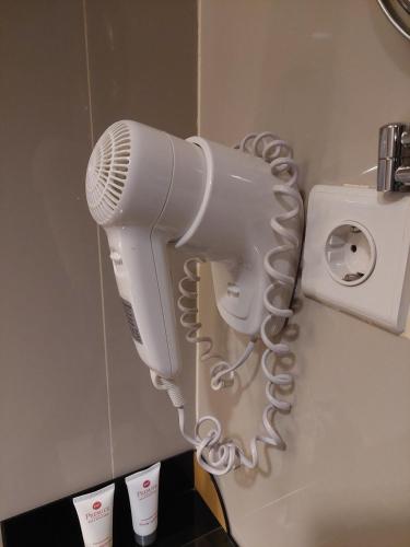 a hair dryer hanging on the wall of a bathroom at Best Western Premier La Grande Bandung in Bandung