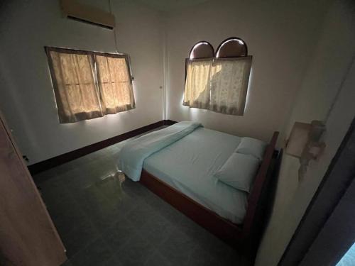 a small bedroom with a bed and two windows at Kata Vl2_Superior in Ban Karon
