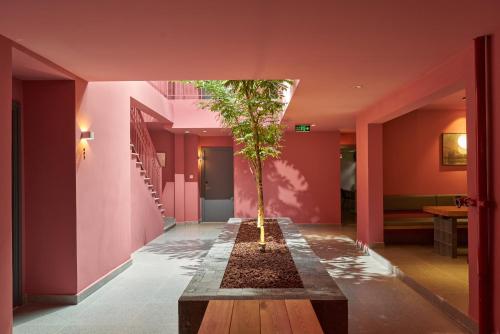 a tree in the middle of a hallway with pink walls at M Village Hồ Biểu Chánh in Ho Chi Minh City