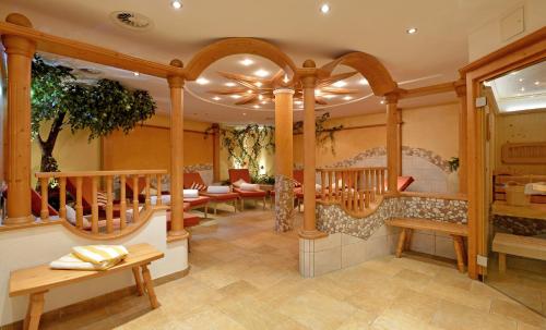 a salon with wooden columns and tables and benches at Apparthotel Ederfeld in Mayrhofen