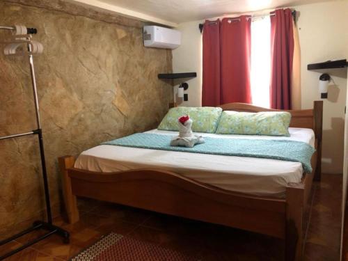 a bedroom with a bed with a teddy bear sitting on it at Cabinas Colibri in Fortuna