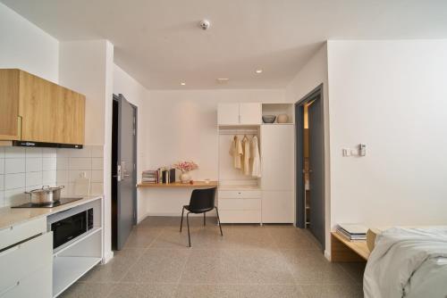 a kitchen and a bedroom with a bed and a chair at M Village Living Hồ Biểu Chánh in Ho Chi Minh City