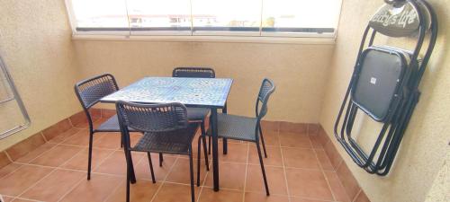 a room with a table and chairs and a window at Apartamento TomCar Piscina, Pádel, wifi y zonas comunes in Sanlúcar de Barrameda