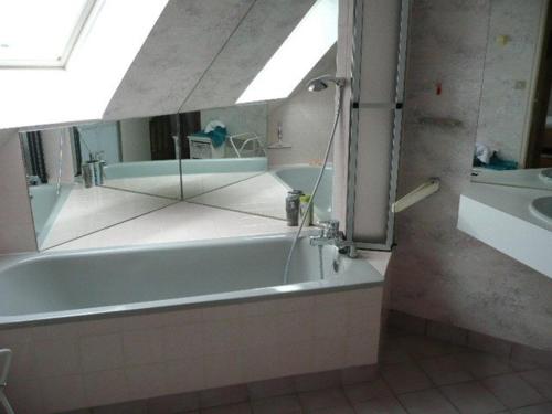 een badkamer met een bad en een spiegel bij Villa Saint-Pierre-Quiberon, 5 pièces, 8 personnes - FR-1-478-13 in Saint-Pierre-Quiberon