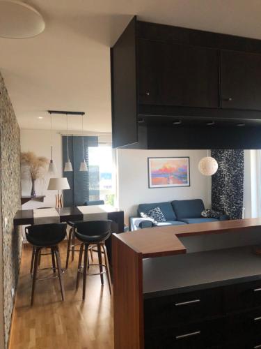 a kitchen and living room with black cabinets and chairs at Apartament 3-pokojowy w sercu Gdańska in Gdańsk