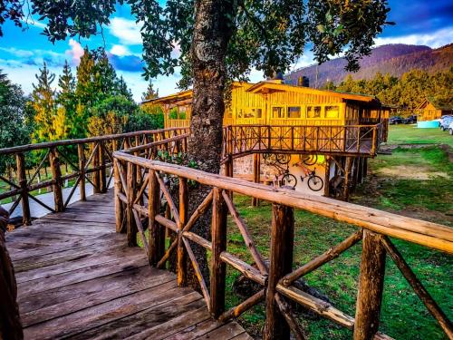 um comboio amarelo estacionado ao lado de uma árvore numa ponte em Los Ilites posada Campestre familiar 