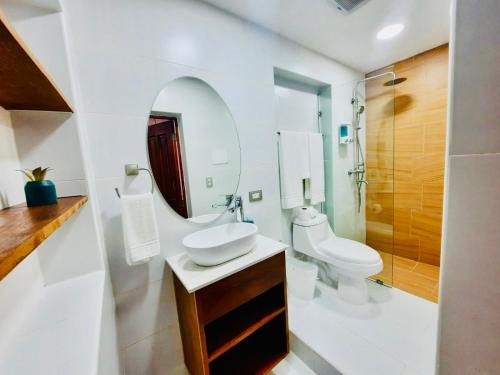a bathroom with a sink and a toilet and a mirror at Lovely Beachfront 2 bedrooms condo with 2 pools in Las Terrenas