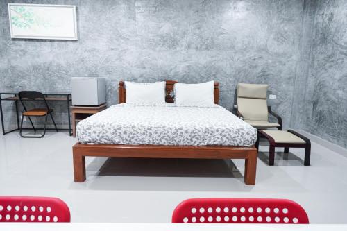 a bedroom with a bed and chairs in a room at Guesthouse Phuket Airport in Ban Bo Han