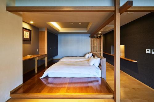 a bedroom with a large bed with white sheets at ITSUKUSHIMA IROHA in Miyajima