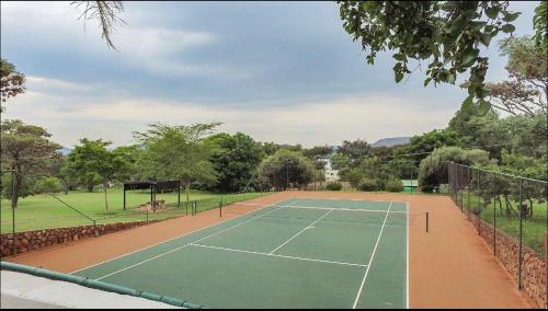a tennis court in a park with a tennis court at The Oasis in Hartbeespoort
