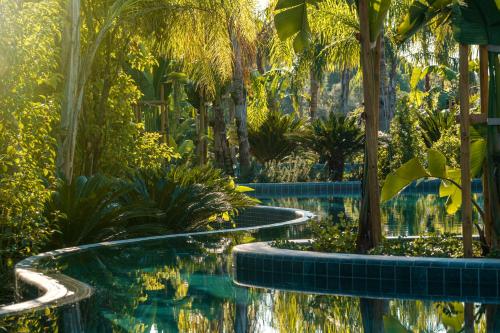 a pool in a garden with trees and plants at Bayou Villas Antalya - Ultra All Inclusive in Antalya