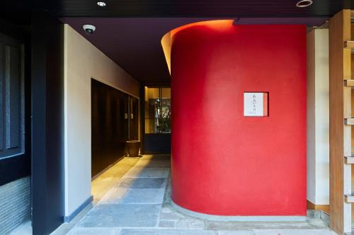 czerwona kolumna w korytarzu z czerwoną ścianą w obiekcie 厳島いろは w mieście Miyajima