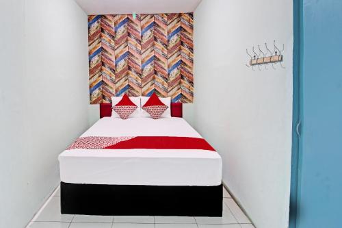 um pequeno quarto com uma cama vermelha e azul em OYO Life 92032 Utama Hotel & Karaoke em Trenggalek