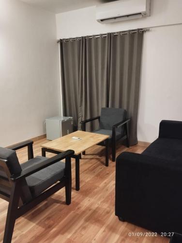 a living room with a table and chairs and a couch at UPAR Hotels Indiranagar in Bengaluru