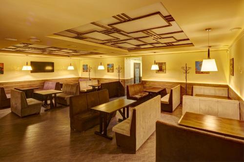 a restaurant with tables and chairs in a room at Three Crowns Hotel in Lviv