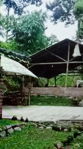 a picnic table with a large umbrella in a yard at Glamping Kalimarno Wonosalam in Tukum