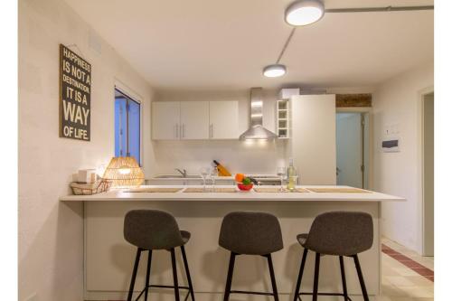 a kitchen with two bar stools and a counter top at POOL & SPA - wellness VILLA St Martin in Mġarr
